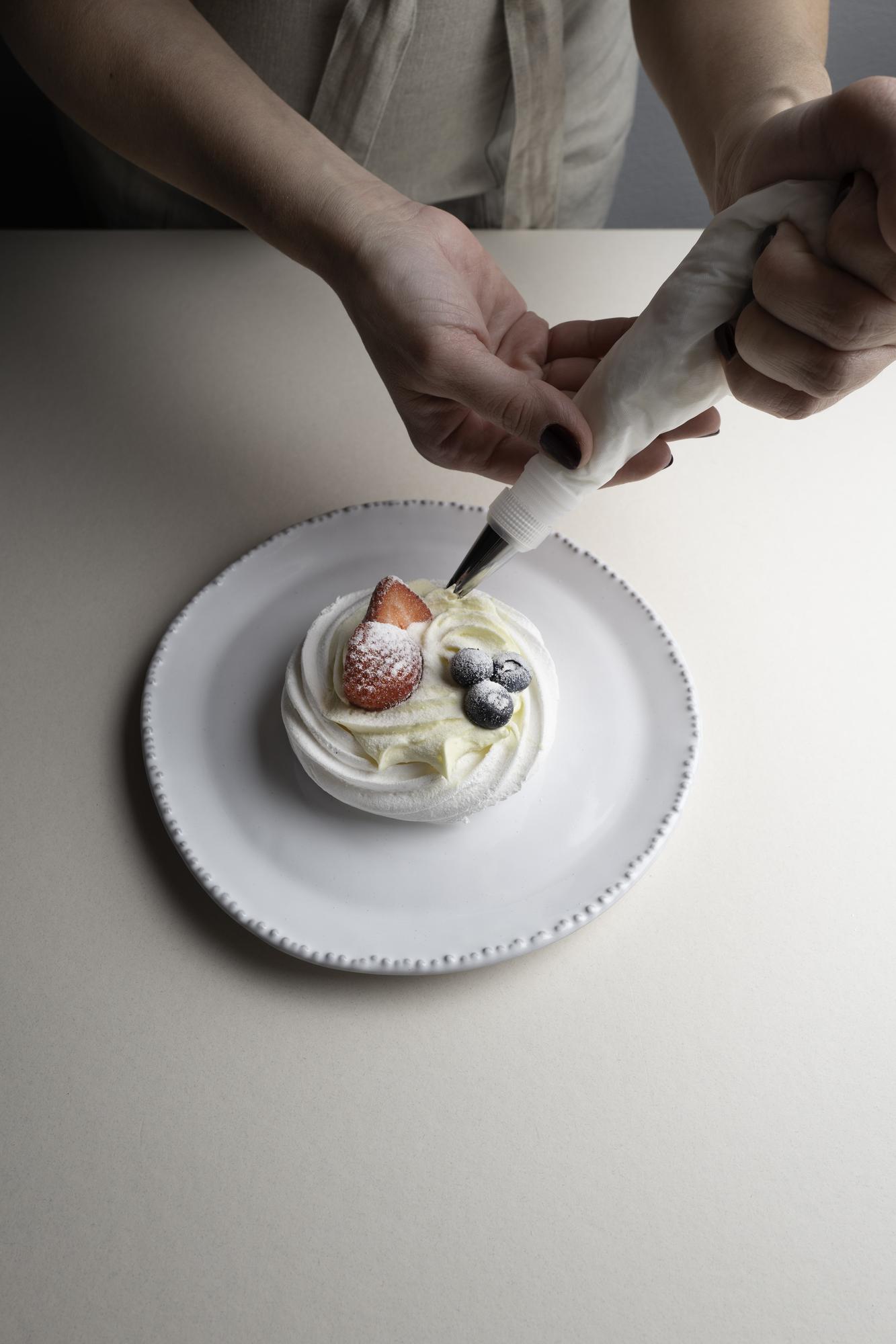 Closeup of hands plating a dessert